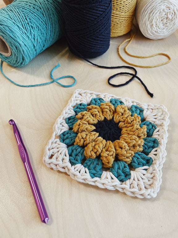 The Daisy Granny Square crocheted with Mustard, Black, Sea Mist, and Natural