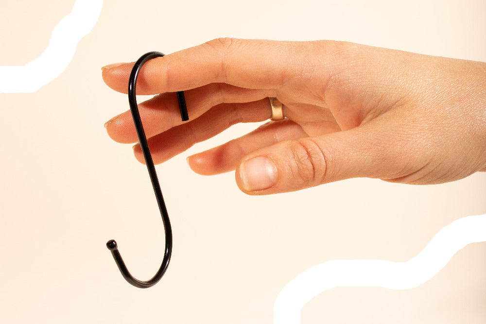 An S hook shown on a hand for size 